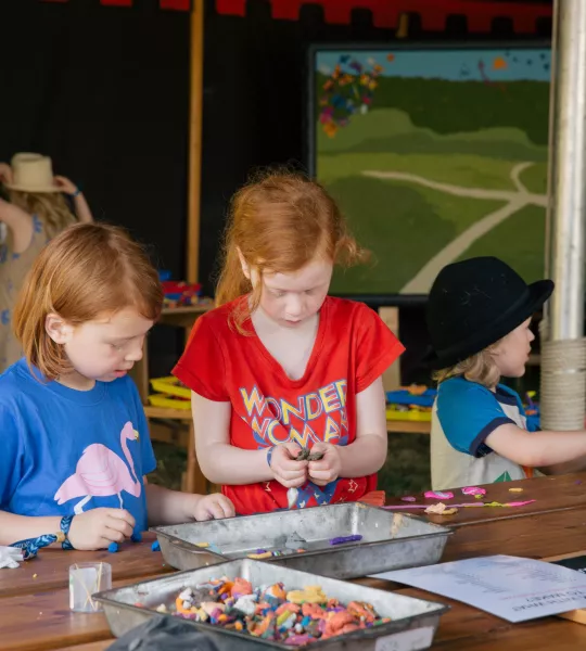 Two children at a table creating models out of colourful modelling clay
