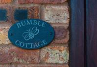Sign reading Bumble Cottage beside front door